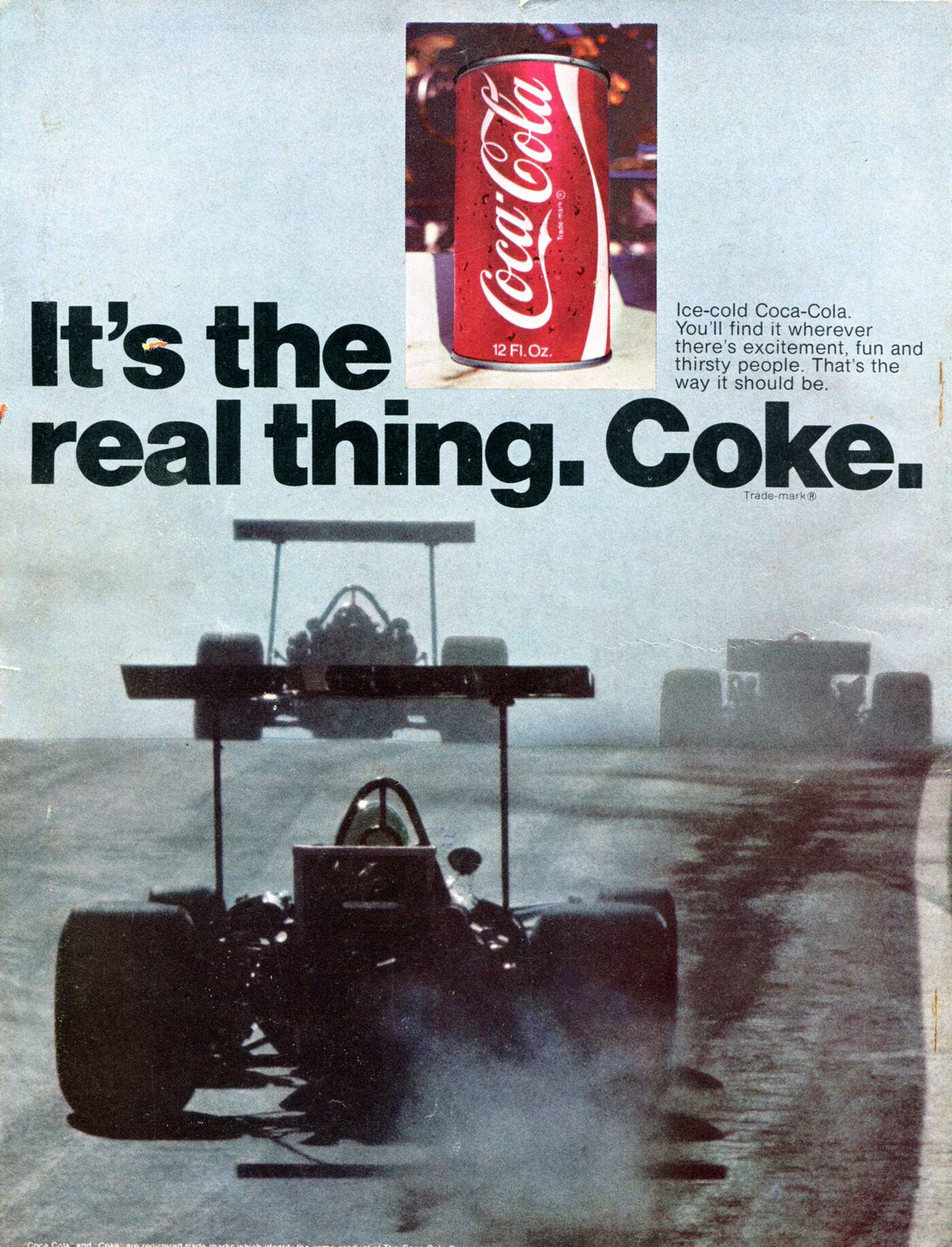 Photo of racecars on a track with the slogan in black helvetica superimposed with a small photo of a can of coke